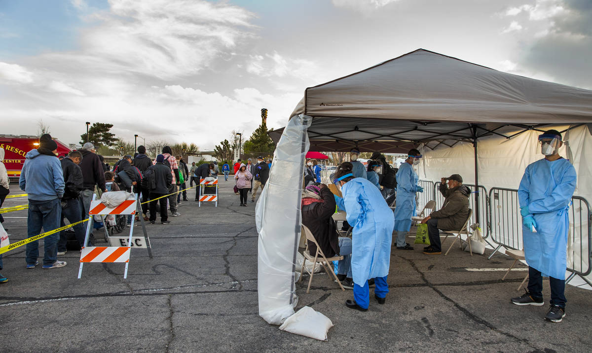 Touro University Nevada medical students, right, screen the homeless as they enter the temporar ...