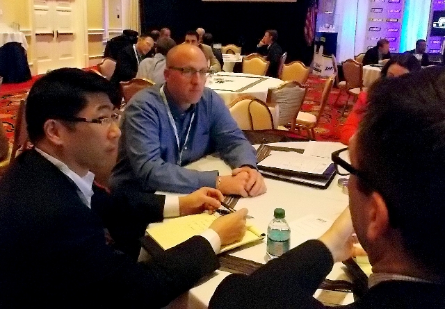 Justin Fantozzi, center, Goodyear marketing manager for global race tires, chats Friday with representatives of 3M at a NASCAR business-to-business session at Encore hotel-casino. NASCAR holds fou ...
