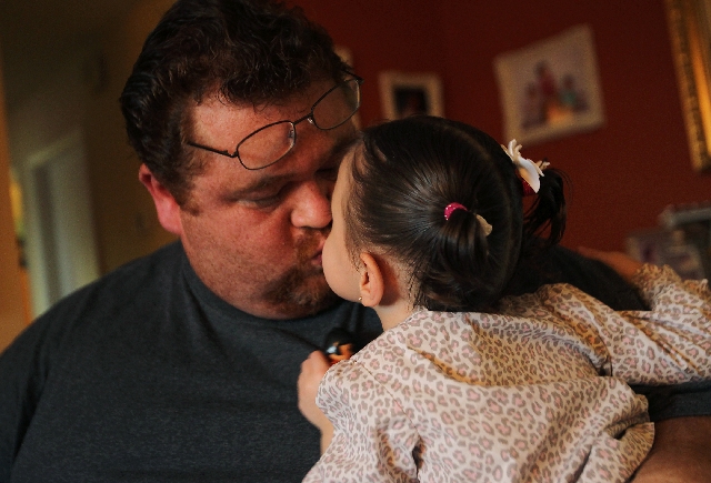 Omar Lazo showers daughter Sandra with affection. Easter Seals helps provide treatment for Lazo’s daughters.