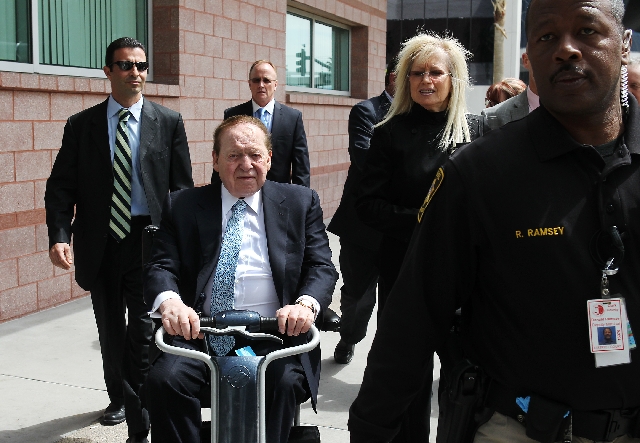 Sheldon Adelson and his wife, Miriam Adelson, enter the Clark County Regional Justice Center in Las Vegas on Thursday.