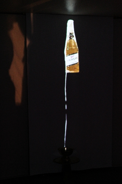 Jenessa Kenway's "High Life," a video installation depicting a stream of beer flowing down a wall, is seen at "The Traveling Miracle Show."