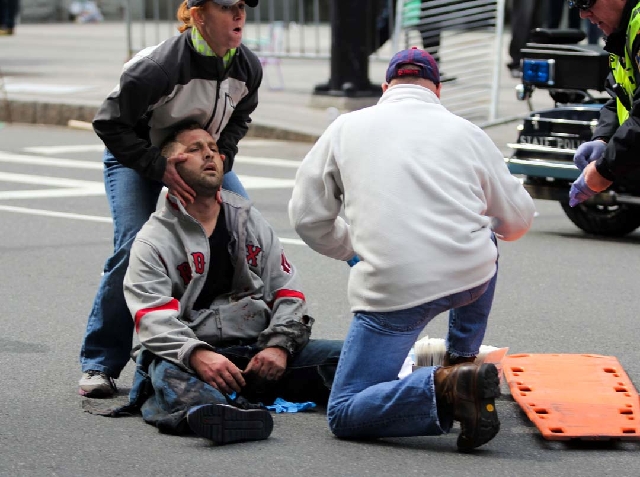 People assist an injured after an explosion at the 2013 Boston Marathon on Monday. Two explosions shattered the euphoria of the Boston Marathon finish line on Monday.
