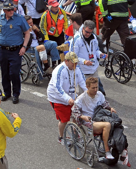Workers aid injured people at the finish line of the 2013 Boston Marathon following an explosion in Boston on Monday.
