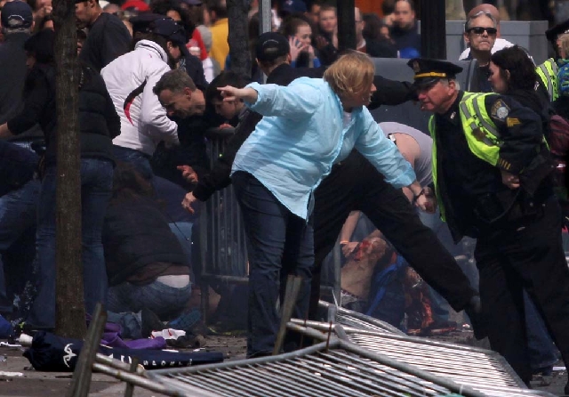People react to an explosion at the 2013 Boston Marathon in Boston on Monday.