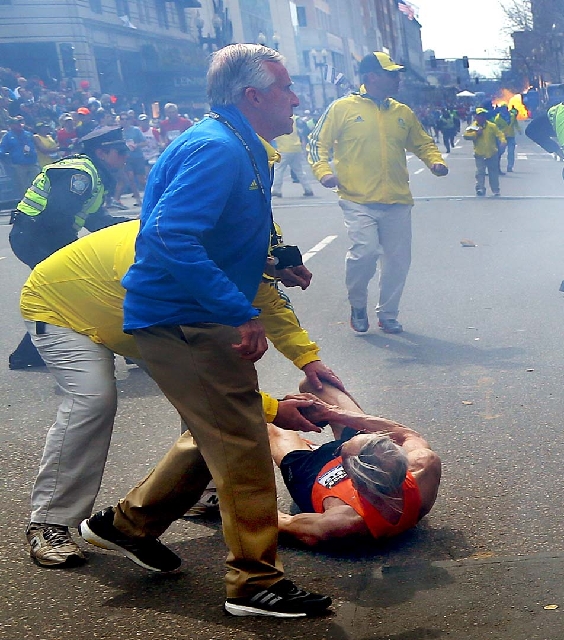 People react to a second explosion at the 2013 Boston Marathon in Boston on Monday. Two explosions shattered the euphoria of the Boston Marathon finish line on Monday, sending authorities out on t ...