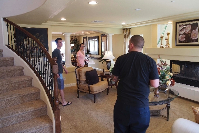 Eric Wennerberg, left, and his sister Emily talk with their friend John Siemer as they tour a model home in April in the Coronado Ranch subdivision in Las Vegas. U.S. new-home sales rose in April  ...