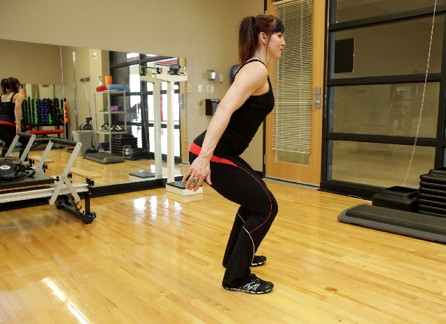 Position the feet hip width apart. Contract the core and straighten the back.