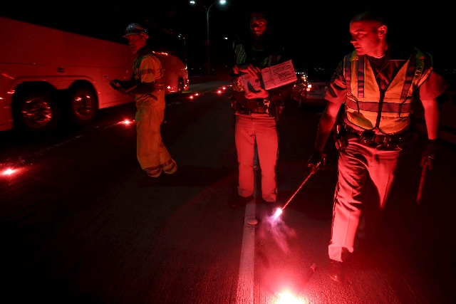 California Highway Patrolmen light flares as they investigate the scene of a limousine fire near San Francisco on Saturday night. Five people died when they were trapped in the limo that caught fi ...