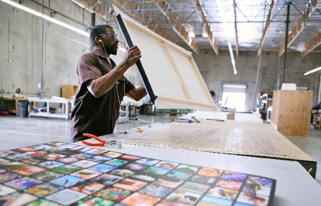 Jermaine Reed stretches a canvas on a wooden frame at CanvasPop on May 9 in North Las Vegas.