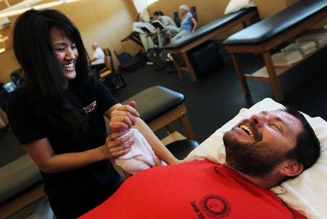 Physical therapist assistant Khristine Rodriguez, left, works on helping Derek Graff regain some flexibility and range of motion to his damaged elbow at Tim Soder Physical Therapy in Henderson. Gr ...