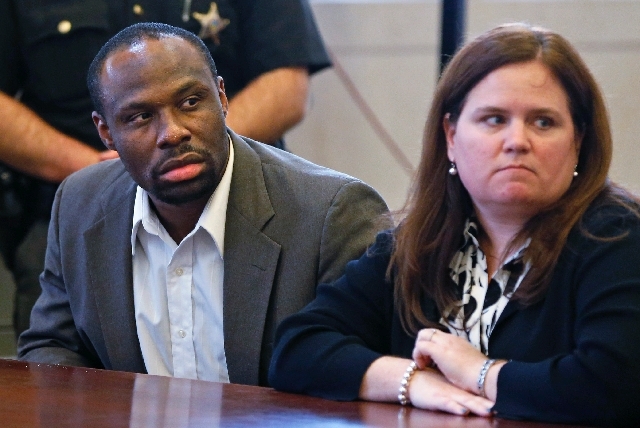 Ricardo Woods, left, sits with attorney Wendy Calaway on Thursday after he was found guilty in the shooting death of a man who authorities say identified his assailant by blinking his eyes while p ...