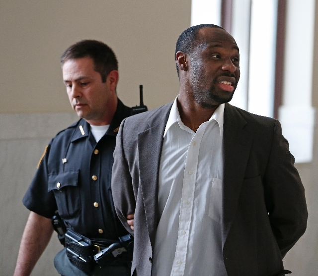 Ricardo Woods is taken from court on Thursday in Cincinnati after he was found guilty in the shooting death of a man who authorities say identified his assailant by blinking his eyes while paralyzed.