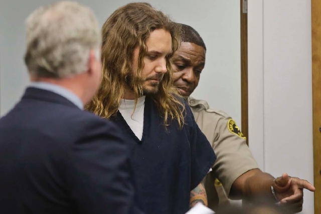 Tim Lambesis, the lead singer for the Metal band As I Lay Dying, is escorted by a San Diego sheriff deputy into Superior Court for his arraignment Thursday on charges he allegedly attempted to hi ...
