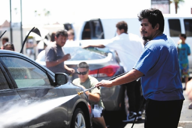 Ivan Arenas, father of Marcos Arenas, washes cars Sunday to raise money for his son's funeral expenses. Marcos died on Thursday after two men attempted to rob him of his iPad.