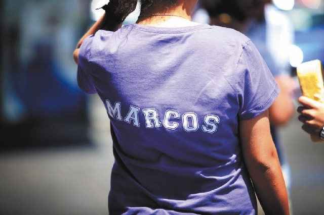 A young woman wears a T-shirt Sunday with 15-year-old Marcos Arenas' name on it at a car wash to raise money for the teen's funeral expenses.