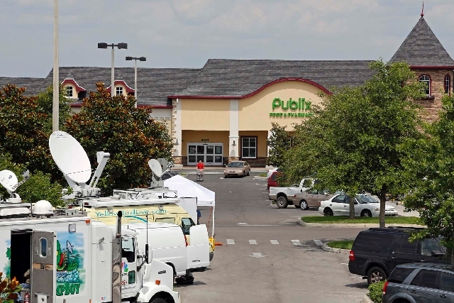 Satellite trucks line the parking lot where the highest Powerball jackpot worth an estimated $590.5 million was sold last week at this Publix supermarket in Zephyrhills, Fla., on Sunday.