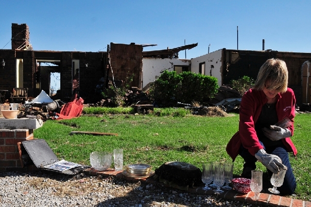Ruth Magers recovers some dishes Saturday from what is left of her friend Bobbie Steenbergen's home in El Reno, Okla., The home was destroyed by the tornadoes that swept through Central Oklahoma F ...