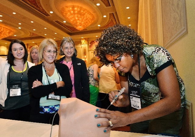 Nurse practitioner Hermine Rosemarie Ariyibi, right, practices giving an injection as, from left, nurse practitioners Jessica Slattery, Deborah Miller and Cathy Fliris look on during a seminar cal ...