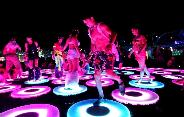 Brian Taraszka of Chicago walks with others on an interactive art installation early Sunday at the Electric Daisy Carnival.