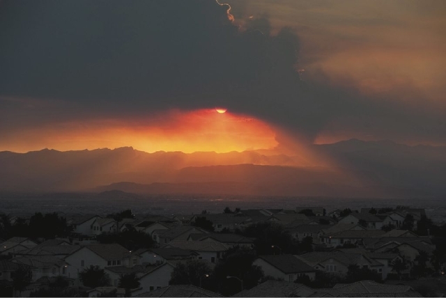 In this view looking west from Henderson, the sun sets behind a column of smoke created by a fire burning in the Carpenter Canyon area of Mt. Charleston on Tuesday. According to the BLM, the fire ...