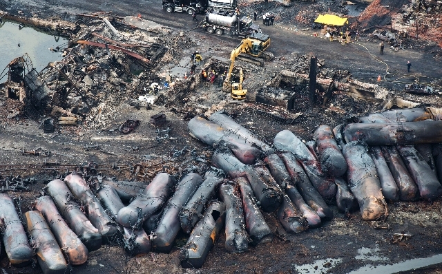 Workers comb through debris Tuesday, July 9, 2013, after a train derailed Saturday causing explosions of railway cars carrying crude oil in Lac-Megantic, Quebec.