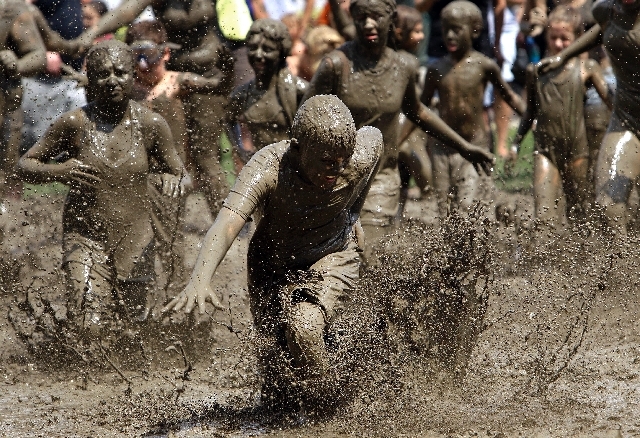 Logan Palshan, 12, of Taylor runs in the mud in Westland, Mich., Tuesday.