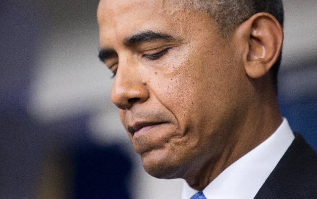 President Barack Obama pauses as he speaks to reporters in the Brady Press Briefing room of the White House in Washington Friday.