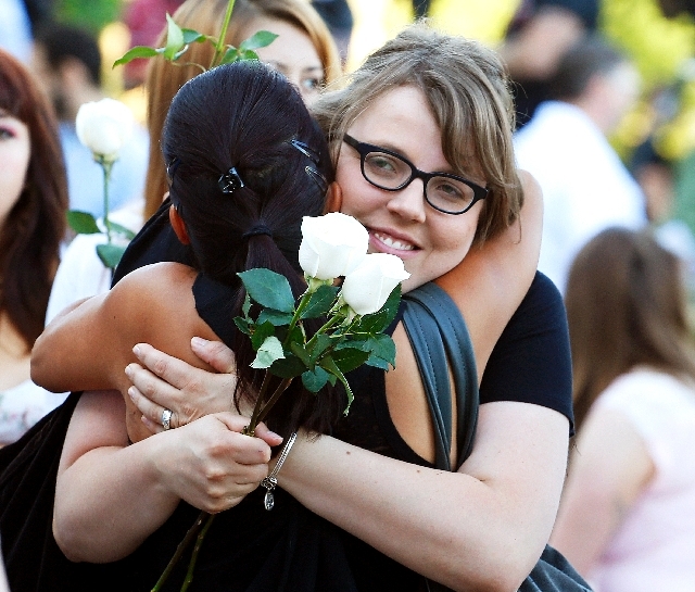 Megan Sullivan, right, the sister of Alex Sullivan who was killed last year in the Aurora movie theater shooting, is hugged by Linda Klosowski at a memorial service in Aurora, Colo., on Saturday. ...