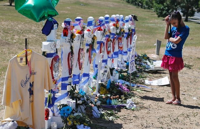 Amilya Scott, 9, visits a temporary memorial for the victims of the Aurora theater shooting in Aurora, Colo., on Saturday.