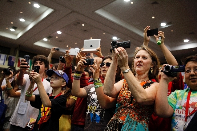 Friends and family take pictures and video during a timed event at the Rubik's Cube World Championships at the Riviera in Las Vegas Saturday.