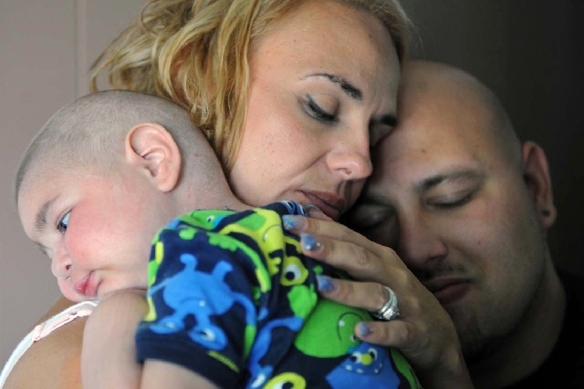 Christine Swidorsky Stevenson holds her son, Logan Stevenson, 2, on July 30 in their Jeannette, Pa., home. At right is her now-husband and Logan's father, Sean Stevenson. The Pennsylvania couple h ...