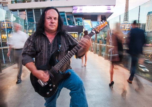 Street performer Michael T. Moore, 46, poses for a portrait on the walking bridge between the Cosmopolitan and the Aria on Friday. Moore who plays the electric guitar, had his amplifier confiscate ...