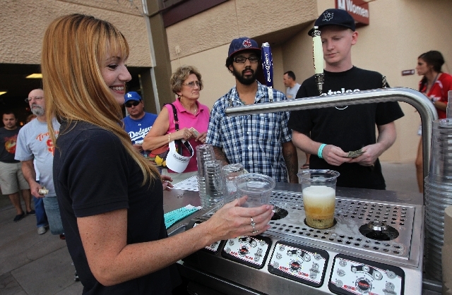 Julie Ludlow, left, serves up dollar beers as a line forms during a 51s baseball game at Cashman Field in Las Vegas on Aug. 8.