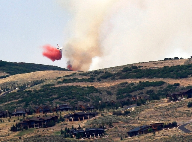 Large air tanker drops fire retardant on fire on ridgetop above US Highway 40 east of Park City, Tuesday, Aug. 13.