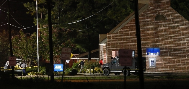 Investigators work throughout the early morning hours Wednesday at the Tensas State Bank branch in St. Joseph, La., where a gunman took three people hostage Tuesday. The suspect, identified as 20- ...