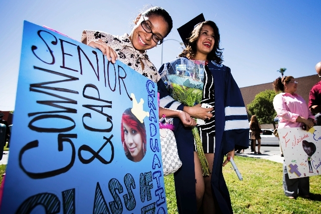 Jacqueline Garay, left, holds a sign in support of Canyon Springs High School graduate Estela Amaya,while standing in front of Theater of the Las Vegas Academy of International Studies, Performing ...