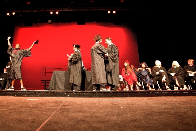 Desert Rose High School student Jerome Washington, left, celebrates on stage while  Clark County School Board member Linda Young waits to give him his diploma during autumn high school graduation  ...