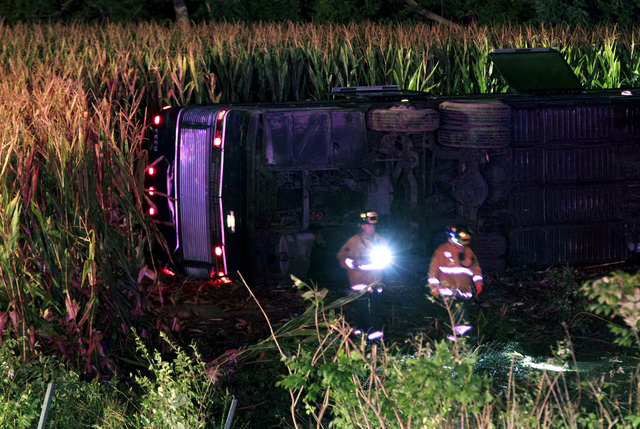 Officials work the scene of an overturned Greyhound bus on interstate I-75 in Liberty Township, Ohio on Saturday, Sept. 14, 2013. Authorities say that at least 35 people have been hurt, with injur ...