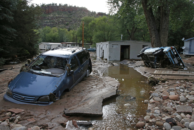 Cars lay mired in mud deposited by floods in Lyons, Colo., Friday Sept. 13. Days of heavy rains and flash floods which washed out the town's bridges and destroyed the electrical and sanitation inf ...