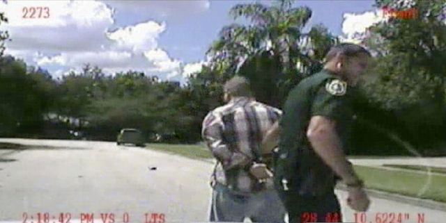 In this image made from dash-cam video and released by the Lake Mary (Fla.) Police, George Zimmerman is detained by officers on Monday, Sept. 9 after Police in central Florida were called via 911 ...
