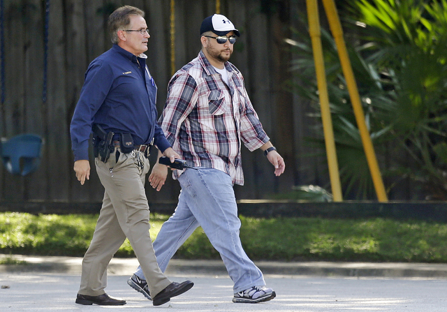 In this Monday, Sept. 9 photo, George Zimmerman, right, is escorted to a home by a Lake Mary police officer, in Lake Mary, Fla., after a domestic incident in the neighborhood where Zimmerman and h ...