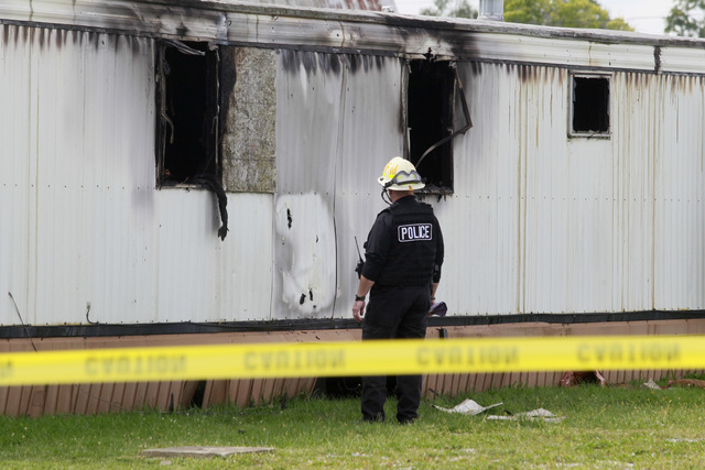 Wm. Timothy Spradlin, with the Division of the State Fire Marshal, investigates into the scene of a fire that killed five children and one adult on Sunday,  Sept. 15, 2013, in Tiffin, Ohio. The fi ...