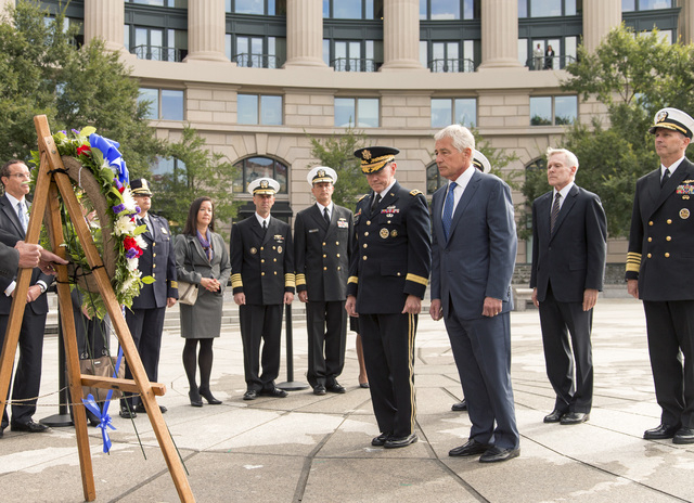 Defense Secretary Chuck Hagel, center right, and Joint Chiefs Chairman Gen. Martin Dempsey lead a delegation Tuesday at the Navy Memorial in Washington to remember the victims of Monday's deadly s ...