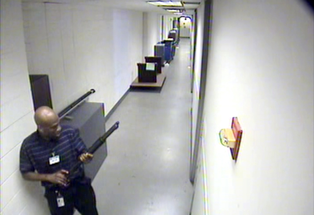 This image from video provided by the FBI, shows Aaron Alexis moves through the hallways of Building #197 at the Washington Navy Yard on Sept. 16 in Washington, carrying a Remington 870 shotgun. A ...