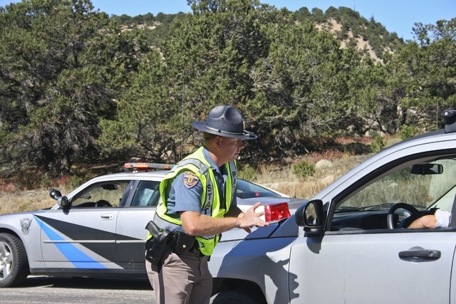Colorado State Patrol Trooper Brandon Wilkins tells a driver Monday Sept. 30, 2013, that the road is closed to all non-emergency traffic while emergency response and law enforcement agencies deal  ...