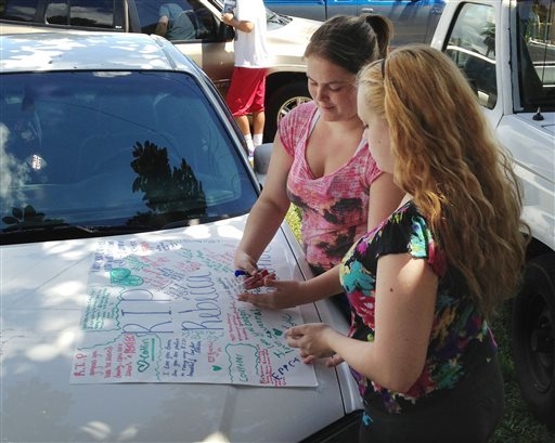 In this Sept. 10 photo, Summer Howard, 19 and Alecia Wilkins, 18, make a poster for Summer's sister Rebecca Sedwick. Polk County Sheriff Grady Judd said that Sedwick jumped to her death on Sept. 9 ...
