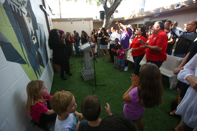 People crowd around during a performance at the grand reopening and ribbon cutting ceremony at the Casa De Luz church in the Naked City area of Las Vegas on Thursday, Sept. 12, 2013. (Chase Steven ...