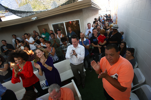 People crowd around and cheer during the grand reopening and ribbon cutting ceremony at the Casa De Luz church in the Naked City area of Las Vegas on Thursday, Sept. 12, 2013. (Chase Stevens/Las V ...