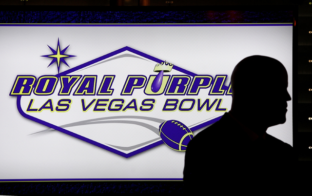 A person stands in front of a screen showing the newly announced sponsor of the Las Vegas Bowl at a luncheon in Las Vegas Wednesday, Sept. 25, 2013.  (John Locher/Las Vegas Review-Journal)