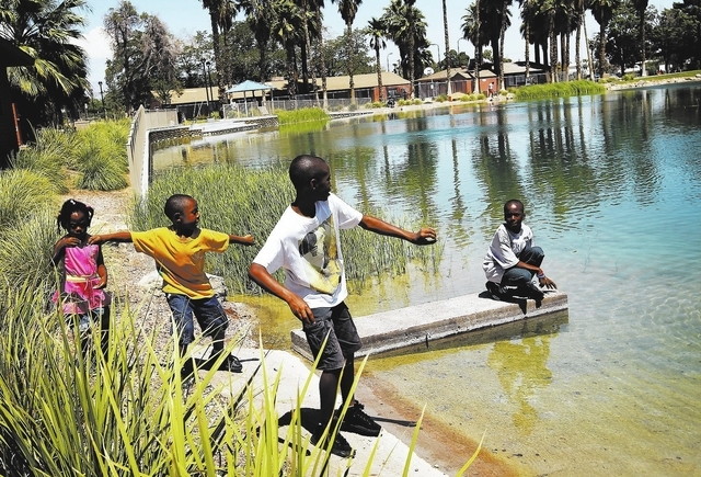 From left, Celine Callender, Jayden Findley, Shemar Findley and Shevaun Findley skip some stones into the pond during the reopening of the newly renovated Lorenzi Park. (Jason Bean/View)